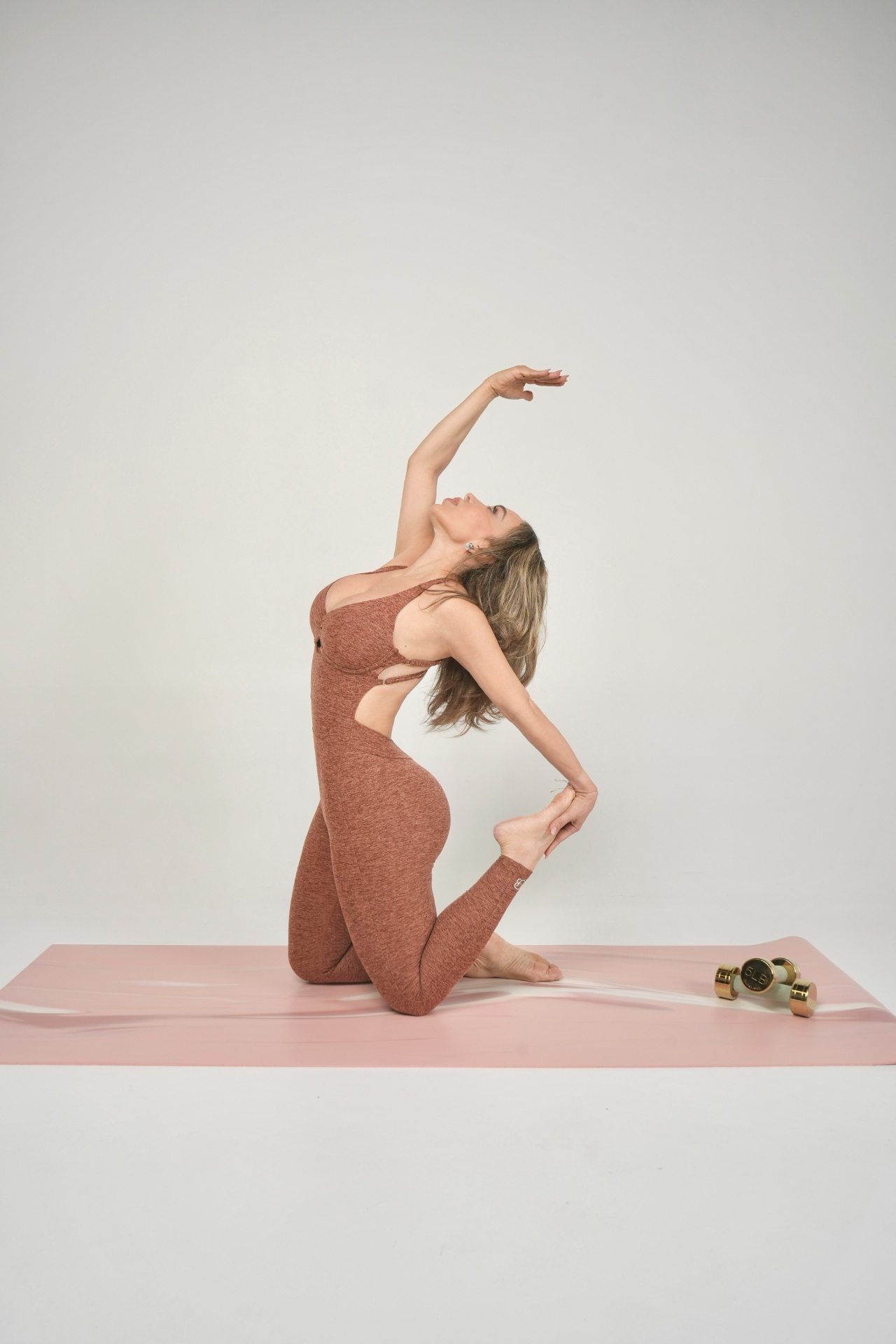 Pilates student in a graceful kneeling backbend pose